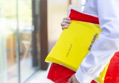 Persona recibiendo un paquete en una bolsa e-commerce